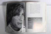 GRAND PRIX: 'THE GRAND PRIX DRIVERS' softcover book. Book signed by 10 World Champions and 5 Grand Prix winners. Signatures include Juan Manuel Fangio, Denis Hulme, Alan Jones, Rene Arnoux, Stirling Moss & Patrick Tambay. Superb signature set - 25