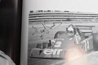 GRAND PRIX: 'THE GRAND PRIX DRIVERS' softcover book. Book signed by 10 World Champions and 5 Grand Prix winners. Signatures include Juan Manuel Fangio, Denis Hulme, Alan Jones, Rene Arnoux, Stirling Moss & Patrick Tambay. Superb signature set - 30