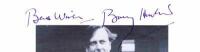 BARRY HUMPHRIES: A black and white picture depicting Barry Humphries holding Moonee Ponds platform sign, autographed "Best Wishes" by Barry Humphries. - 2