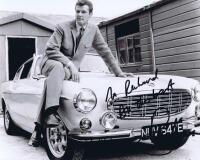 THE SAINT: A black and white picture depicting 'The Saint' Roger Moore and the Volvo P1800 coupe, autographed by Roger Moore.
