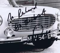 THE SAINT: A black and white picture depicting 'The Saint' Roger Moore and the Volvo P1800 coupe, autographed by Roger Moore. - 2