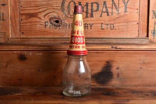 SHELL: A circa 1930s "Shell" embossed one imperial pint oil bottle, with circa 1950s "SHell 40 X-100" tin pourer and dust cover