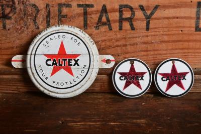 CALTEX: Three Caltex items including a metal drum seal, two plastic key ring medallions with the service station details of Strickland's and Frejay (Sunshine) on reverse