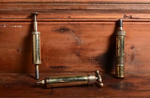 CASTROL WAKEFIELD: Three antique brass grease guns, the one with the domed trigger&nbsp;branded 'Wakefield Castrol, largest aprox 15cm long