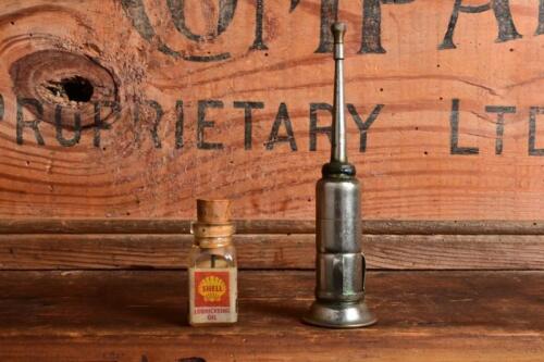 SHELL: A circa 1950s/1960s glass Shell 'Scalextric' model car oil together with a small oiler with cigarette holder mounting clips, largest 11cm high