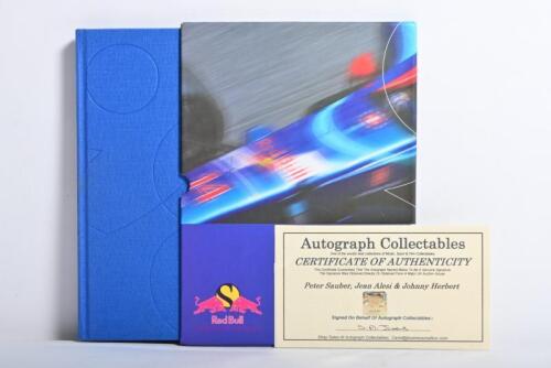 RED BULL SAUBER: A hard copy version of 'Red Bull SAUBER PETRONAS 1998 YEARBOOK'. Book signed by Peter Sauber, Jean Alesi & Johnny Herbert. 'Autograph Collectables' CoA