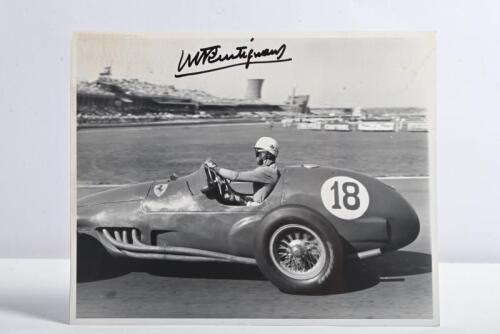 TRINTIGNANT: A superb 'THE GEORGE MONKHOUSE COLLECTION' black and white photograph depicting a scene from the 1955 British Grand Prix of Maurice Trintignant racing a Ferrari 625. Maurice Trintignant signature