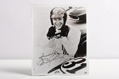 GURNEY: A black and white picture of Dan Gurney beside a race car. Dan Gurney signature. Picture circa 1960's