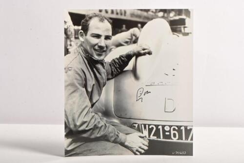 MOSS: A black and white image of Stirling Moss posing besides the Mercedes-Benz 300SLR. Moss signature