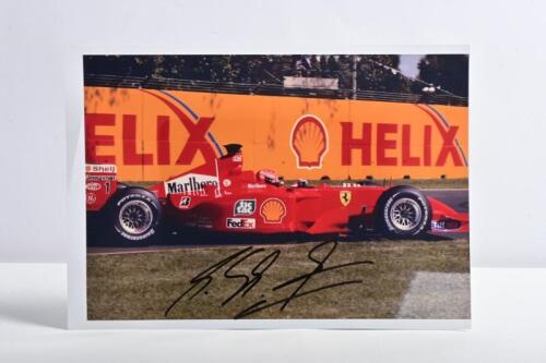SCHUMACHER: A colour image of Michael Schumacher racing a Ferrari F399. Michael Schumacher signature