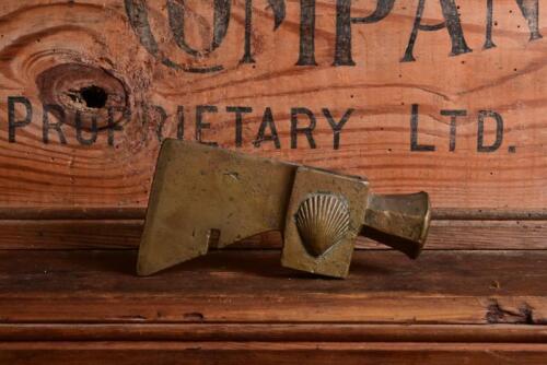 SHELL: A rare and early brass embossed hammer head for drum opening, 14.5cm wide
