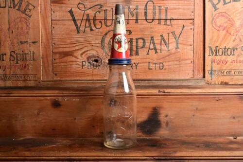 TEXACO: A mid 20th century "Texaco" embossed one quart oil bottle, with original mid 20th century "Texaco 40" tin pourer and dust cover, with rivet air hole