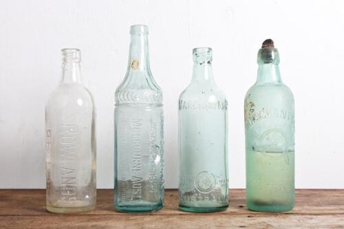 LEMONADE BOTTLES: Four antique embossed twenty-six ounce glass bottle, including two "Marchant & Co" one with cork and contents