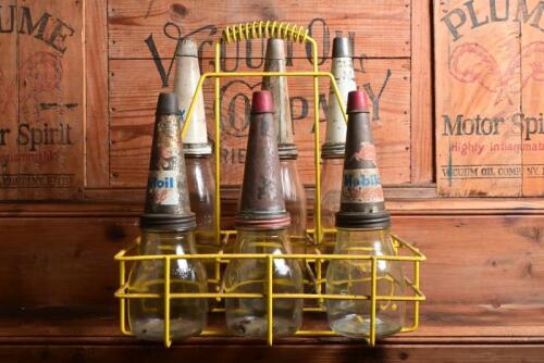 MOBIL: A collection of imperial pint and quart oil bottles with mid 20th century "Mobil" tin oil pourer and dust covers in wire rack, comprising three imperial pint bottles and three quart bottles