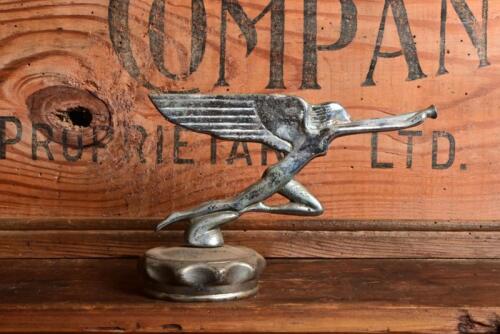 MASCOT: A mascot in the form of a winged angel blowing trumpet on plated radiator cap, 10cm high overall
