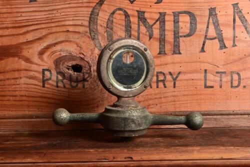 MASCOT: An early American 'Botce Moto Meter' temperature gauge with bevelled glass and fitted to dog bone form base, 13.5cm high
