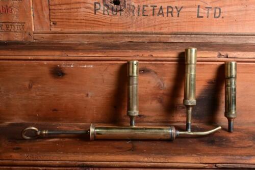 GREASE GUNS: A collection of four antique grease guns, largest 28cm long (closed)