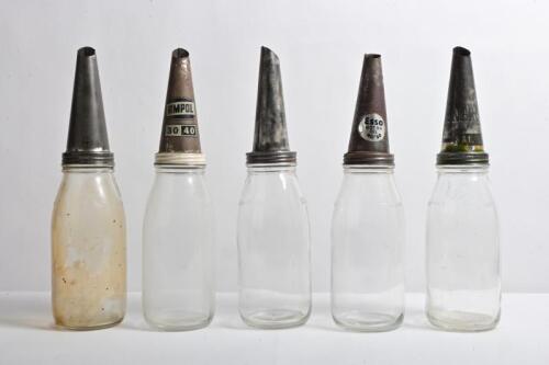 OIL BOTTLES: A collection of five one quart oil bottles with various tin faded pourers&nbsp;including "Energol", "Mobiloil" and "Shell"