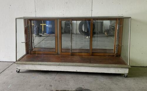 DISPLAY CASE: An early 20th century mirror backed nickle and glass display counter, with two glass shelves and three sliding rear doors, 107cm high, 214cm, wide, 56cm deep